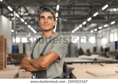 Portrait of young male carpenter standing in the wood workshop
