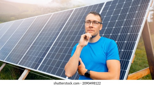 Portrait Young Male Farmer In Glasses On Background Of Solar Panels. Concept Maintenance Of Electrical Elements Is Self Sufficient.