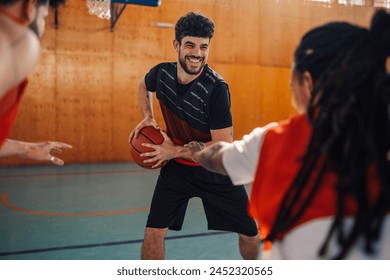 Portrait of a young male smiling caucasian basketball player guarding the ball while playing the game or having a practice with his multiracial team indoor. Copy space. - Powered by Shutterstock