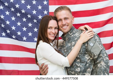 Portrait Of Young Male Soldier With His Wife In Front Of American Flag - Powered by Shutterstock