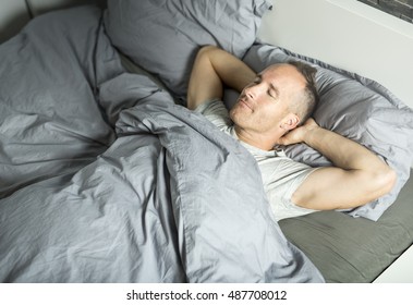 A Portrait Of A Young Man From Above Sleeping In A Bed.