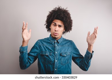 Portrait Of A Young Man With Afro Asking Questions With Hands Raised