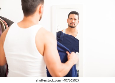 Portrait Of A Young Man With A Beard Getting Dressed And Trying A Shirt. Plenty Of Copy Space