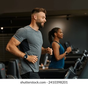 Portrait of a young man and a black woman exercising in a gym, running using  thereadmill machine equipment, healthy lifestyle and cardio exercise at fitness club concepts - Powered by Shutterstock