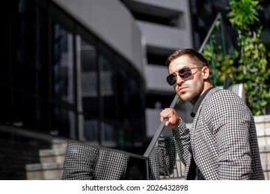 Portrait Of A Young Man In The City Dressed Bussines. Young Sucessful Businesman Is Posing For Photographer Near His Office