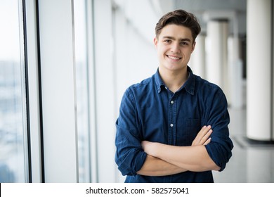 Portrait of young man with crossed hands near in window. - Shutterstock ID 582575041