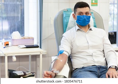 Portrait Of Young Man Donor In Medical Mask From Coronavirus Donation Blood In Laboratory. Prevention Of Covid-19 In Hemodialysis Transfusion Unit In Hospital.