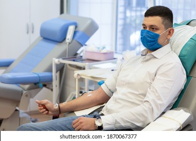 Portrait Of Young Man Donor In Medical Mask From Coronavirus Donation Blood In Laboratory. Prevention Of Covid-19 In Hemodialysis Transfusion Unit In Hospital.