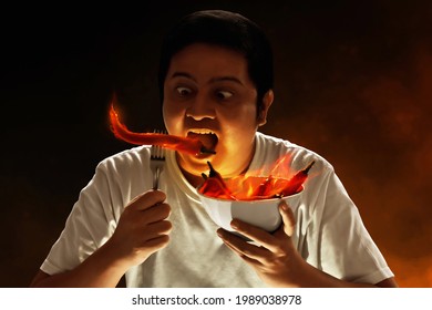 Portrait Of Young Man Eating Chili Pepper