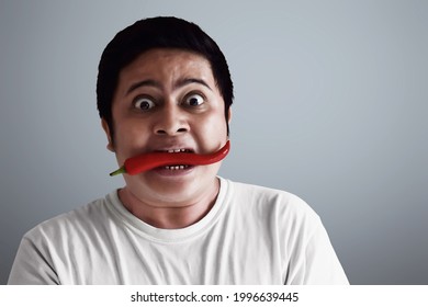 Portrait Of Young Man Eating Chili Pepper