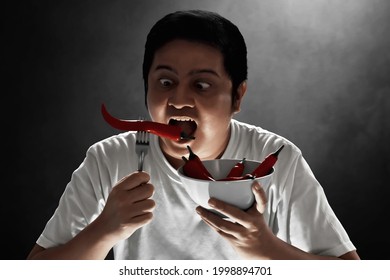 Portrait Of Young Man Eating Chili Pepper