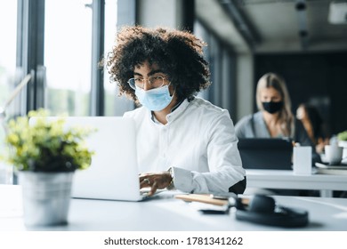 Portrait of young man with face mask back at work in office after lockdown. - Powered by Shutterstock