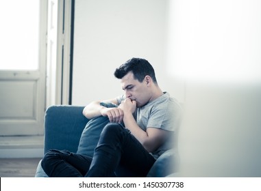 Portrait Of Young Man Felling Depressed And Desperate Crying Alone In Sofa Home Suffering Emotional Pain And Unhappiness. In People Broken Heart, Bullying Depression And Mental Health Issues Concept.