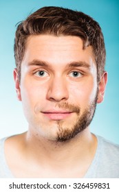 Portrait Of Young Man With Half Shaved Face Beard Hair. Handsome Guy On Blue. Skin Care And Hygiene.