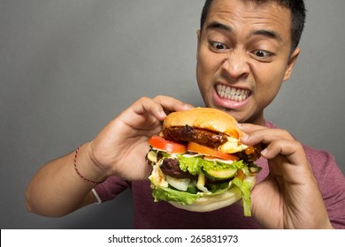 A portrait of young man have a great desire to eat a burger