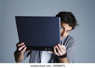 Portrait Of Young Man Holding Laptop, Studio Shot