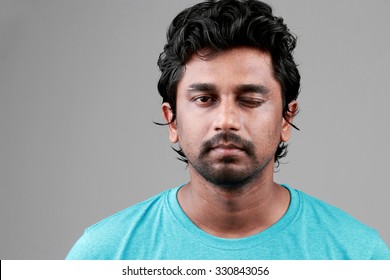 Portrait Of A Young Man Of Indian Origin With One Eye Closed