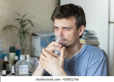 Portrait Of Young Man Inhaling Through Inhaler Mask