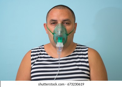 Portrait Of Young Man Inhaling Through Inhaler Mask