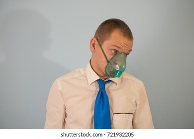 Portrait Of Young Man Inhaling Through Inhaler Mask