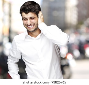 Portrait Of A Young Man Irritated Hearing A Loud Noise Against A City Background