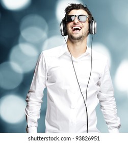 Portrait Of A Young Man Listening To Music With Headphones Against An Abstract Background