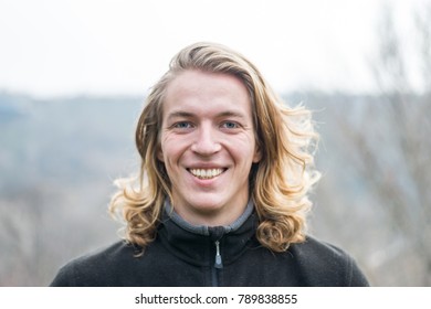 Portrait Of A Young Man With Long Hair And A Genuine Smile, Outdoors. Portrait Of A Man.