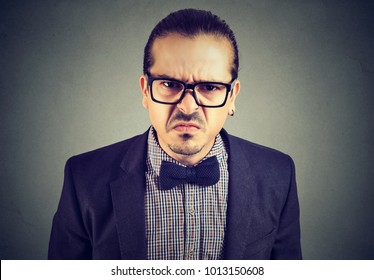 Portrait Of Young Man Looking Dissatisfied At Camera With Grumpy Facial Expression.