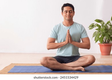 Portrait of a young man meditating at home - Powered by Shutterstock