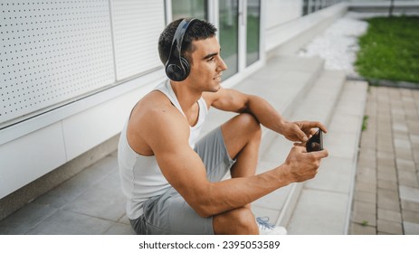 Portrait of young man outdoor use headphones and smart phone to play video games - Shutterstock ID 2395053589