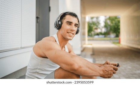 Portrait of young man outdoor use headphones and smart phone to play video games - Shutterstock ID 2395053599