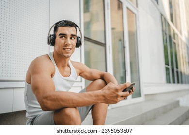 Portrait of young man outdoor use headphones and smart phone to play video games - Shutterstock ID 2395053607