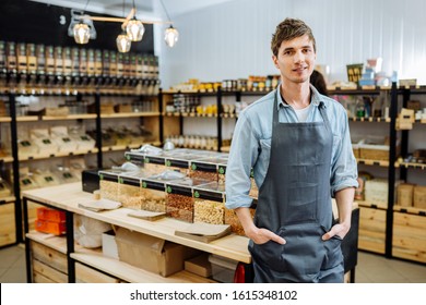 Portrait of young man owner over interior of Zero Waste Shop in Grocery Store. No plastic Conscious Minimalism Vegan Lifestyle Concept.