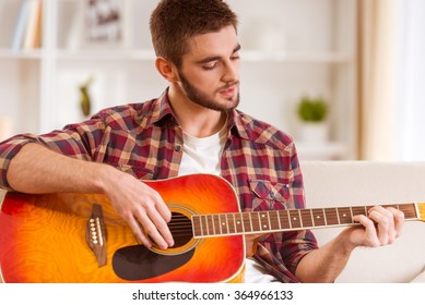 Portrait Of A Young Man Playing The Guitar At Home