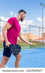 Portrait of a young man playing pickleball. Young man going to perform the serve point in pickleball.
