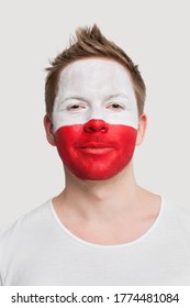 Portrait Of Young Man With Polish Flag Painted On Face Smiling Against White Background