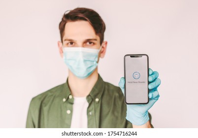 Portrait Young Man In Protective Face Mask And Medical Glove Use Mobile Phone For Digital Contact Less Purchase Isolated White Background. Happy Man Hold Smart Phone In Hand. Electronic Mobile Payment