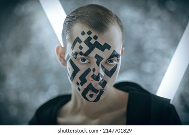 Portrait of a young man with a QR-code painted on his face standing at futuristic neon lamps and looking indifferently at the camera. Modern technologies of human personification. 