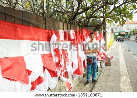portrait of a young man selling the Indonesian national flag beside street