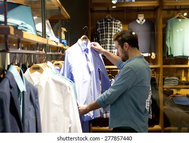 Portrait Of A Young Man Shopping For Clothes At Store