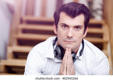 Portrait of young man sitting at the stairs in office - Shutterstock ID 402965266