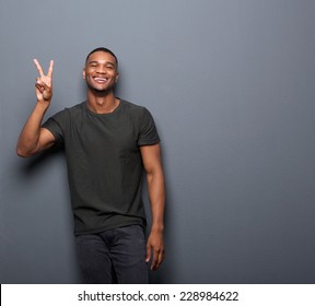 Portrait Of A Young Man Smiling Showing Hand Peace Sign