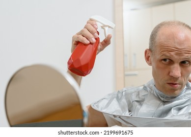 Portrait Of Young Man Spraying Hair Before Cutting