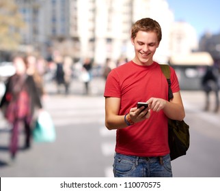 Portrait Of Young Man Touching Mobile Screen At Crowded Street