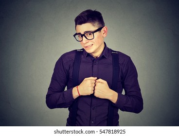 Portrait Young Man In Unpleasant Awkward Situation Playing Nervously With Hands Isolated On Gray Background. Negative Emotions