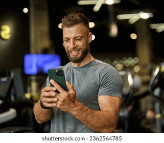 Portrait of a young man using a phone ant exting taking a break exercising in a gym, running using  thereadmill machine equipment, healthy lifestyle and cardio exercise at fitness club concepts - Powered by Shutterstock