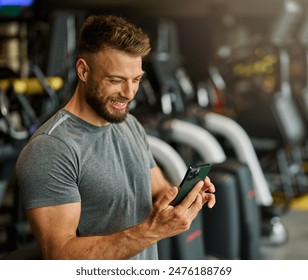 Portrait of a young man using a phone ant exting taking a break exercising in a gym, running using  thereadmill machine equipment, healthy lifestyle and cardio exercise at fitness club concepts - Powered by Shutterstock