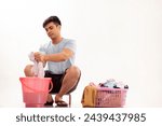 Portrait of young man washing clothes by hand