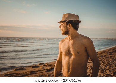 Portrait. Young man watching the sunset on the beach on a day of summer. Concept of thinking and relaxation - Powered by Shutterstock