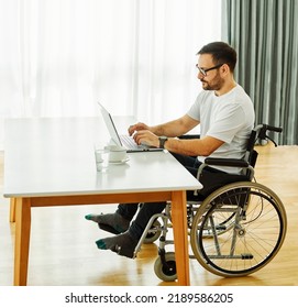 Portrait Of A Young Man In Wheelchair Using Laptop At Home Office Or In Hospital Lives With Disability, Man Who Is Paralyzed